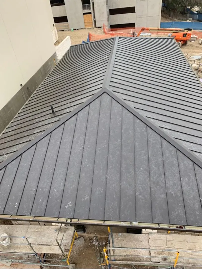 Commercial metal roof construction with crane equipment in North Caldwell